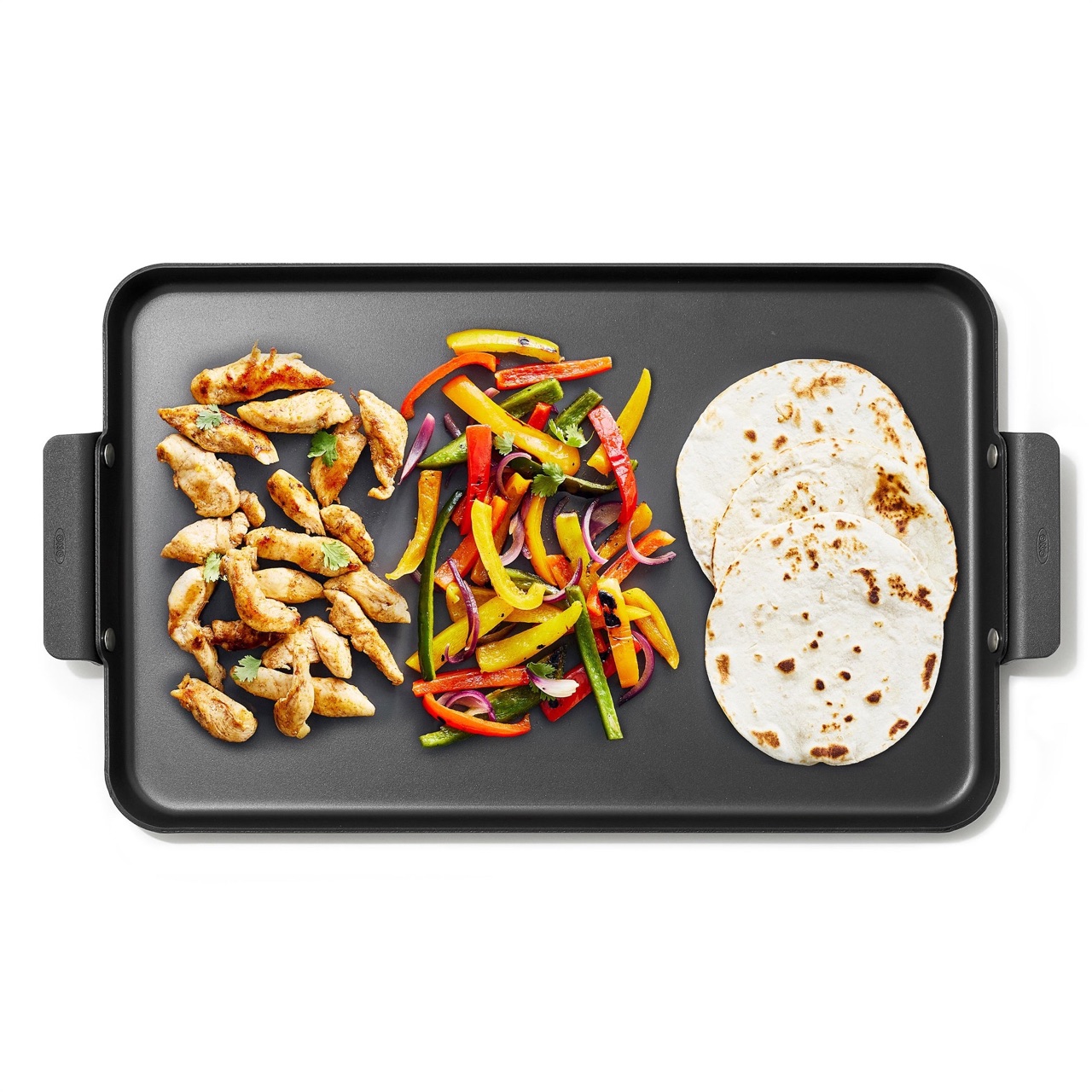 Chicken, peppers and tortillas cooking side by side on the OXO Outdoor double burner griddle