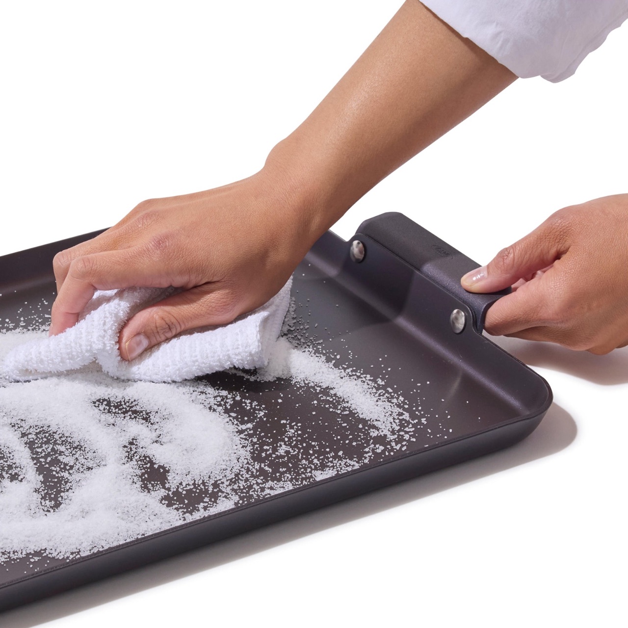 Scrubbing the OXO Outdoor double burner griddle with coarse salt and a cloth