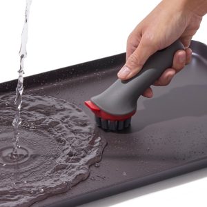 Hand washing the OXO Outdoor double burner griddle with a brush
