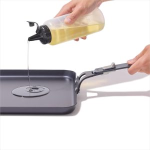 Wiping oil onto the OXO Outdoor carbon steel griddle pan after cleaning